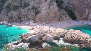 Sardegna 'nın Orosei Körfezi' ndeki Cala Baunei 'nin beyaz kumlu hava aracı görüntüsü. Sardunya adasında yeşil dağlarla çevrili ılık turkuaz deniz ve küçük plaj.
