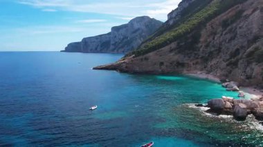 Sardegna 'nın Orosei Körfezi' ndeki Cala Baunei 'nin beyaz kumlu hava aracı görüntüsü. Sardunya adasında yeşil dağlarla çevrili ılık turkuaz deniz ve küçük plaj.