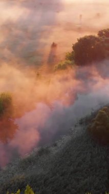 Güneşin sisli nehir üzerinde doğuşunu gösteren hava aracı görüntüsü. Sakinlik, rahatlama, meditasyon, yalnızlık, doğa konseptinin güzelliği.