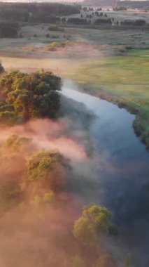 Güneşin sisli nehir üzerinde doğuşunu gösteren hava aracı görüntüsü. Sakinlik, rahatlama, meditasyon, yalnızlık, doğa konseptinin güzelliği.