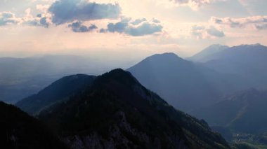 Slovenya 'nın Kranjska Gora kentindeki günbatımı sıradağları üzerinde uçan hava aracı. İzleme görüntüsü