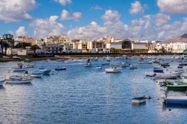 Arka planda modern mimari ve volkanik dağlar tarafından çerçevelenmiş tekneler yavaşça Arrecife Gölünde yüzer. Huzurlu güzellikler ve hareketli manzaralar ziyaretçileri cezbediyor.