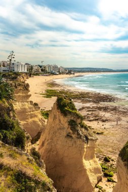 Yedi Asılı Vadi ve Altın Kumlu Plaj 'ın ikonik uçurumlarının çarpıcı görüntüsü. Berrak mavi okyanusa karşı uzanan sakin kıyı şeridi Portekiz 'in doğal güzelliklerini yakalıyor.