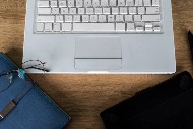 Tahta bir masanın üstünde duran bir dizüstü bilgisayar.