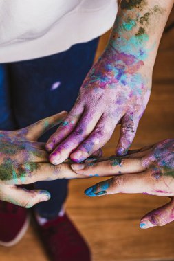 Elleri boyayla kaplı bir grup insan.