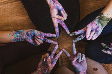 Elleri farklı renklerde boyanmış bir grup insan.