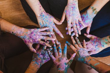 Elleri farklı renklerde boyanmış bir grup insan.