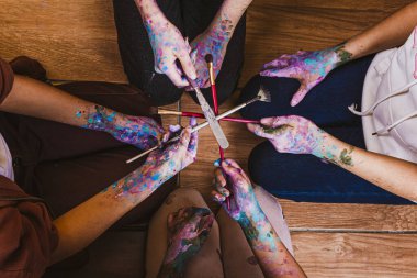 Ellerinde boya olan bir grup insan.