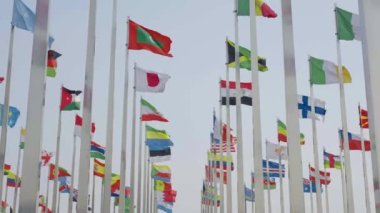 Dünyanın bayraklarının mavi gökyüzü arka planında dalgalanmasının alt görünümü