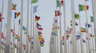 Dünyanın bayraklarının mavi gökyüzü arka planında dalgalanmasının alt görünümü