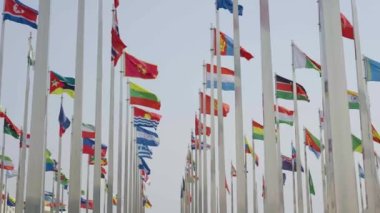Dünyanın bayraklarının mavi gökyüzü arka planında dalgalanmasının alt görünümü