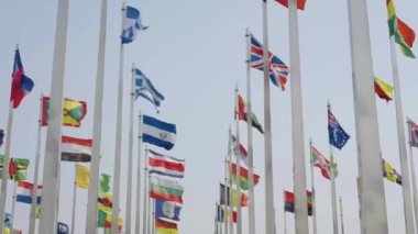 Dünyanın bayraklarının mavi gökyüzü arka planında dalgalanmasının alt görünümü