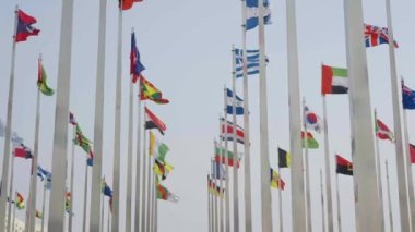 Dünyanın bayraklarının mavi gökyüzü arka planında dalgalanmasının alt görünümü