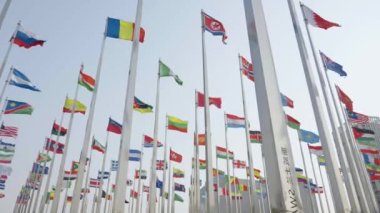 Dünyanın bayraklarının mavi gökyüzü arka planında dalgalanmasının alt görünümü
