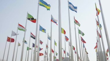 Dünyanın bayraklarının mavi gökyüzü arka planında dalgalanmasının alt görünümü