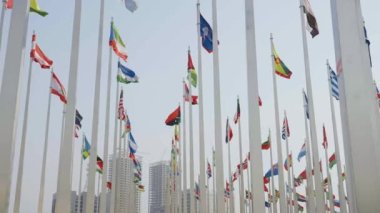 Dünyanın bayraklarının mavi gökyüzü arka planında dalgalanmasının alt görünümü