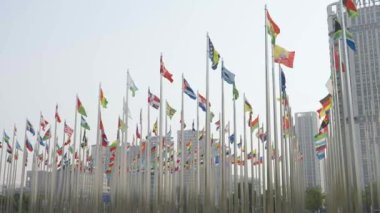 Dünyanın bayraklarının mavi gökyüzü arka planında dalgalanmasının alt görünümü