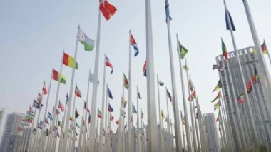 Dünyanın bayraklarının mavi gökyüzü arka planında dalgalanmasının alt görünümü