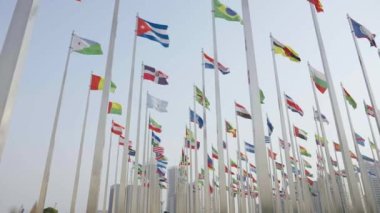 Dünyanın bayraklarının mavi gökyüzü arka planında dalgalanmasının alt görünümü