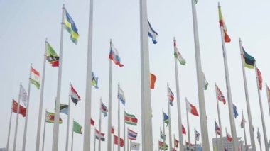 Dünyanın bayraklarının mavi gökyüzü arka planında dalgalanmasının alt görünümü