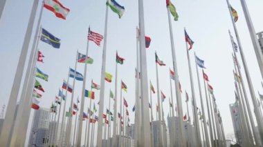 Dünyanın bayraklarının mavi gökyüzü arka planında dalgalanmasının alt görünümü