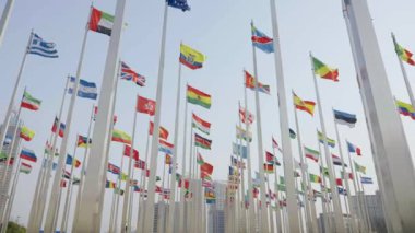 Dünyanın bayraklarının mavi gökyüzü arka planında dalgalanmasının alt görünümü
