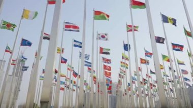 Dünyanın bayraklarının mavi gökyüzü arka planında dalgalanmasının alt görünümü