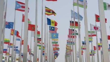 Dünyanın bayraklarının mavi gökyüzü arka planında dalgalanmasının alt görünümü