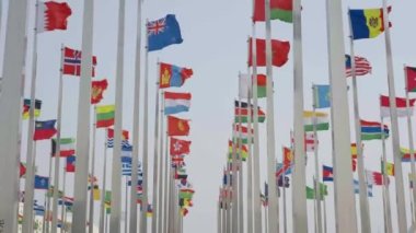 Dünyanın bayraklarının mavi gökyüzü arka planında dalgalanmasının alt görünümü