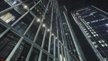 Gece gökyüzünün önündeki iş binalarının teknoloji efektli alt görüntüsü