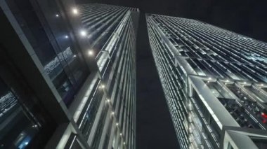 Gece gökyüzünün önündeki iş binalarının teknoloji efektli alt görüntüsü