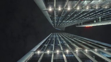 Gece gökyüzünün önündeki iş binalarının teknoloji efektli alt görüntüsü