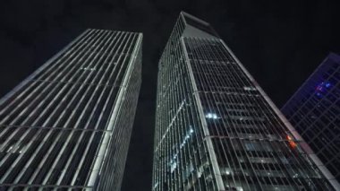 Gece gökyüzünün önündeki iş binalarının teknoloji efektli alt görüntüsü