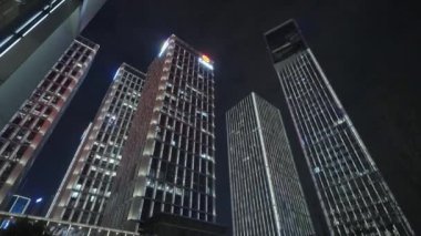 Gece gökyüzünün önündeki iş binalarının teknoloji efektli alt görüntüsü