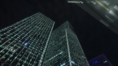 Gece gökyüzünün önündeki iş binalarının teknoloji efektli alt görüntüsü