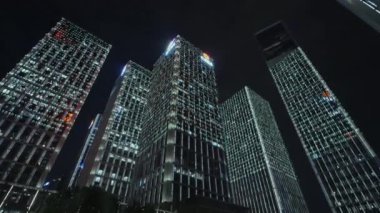 Gece gökyüzünün önündeki iş binalarının teknoloji efektli alt görüntüsü