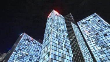 Gece gökyüzünün önündeki iş binalarının teknoloji efektli alt görüntüsü
