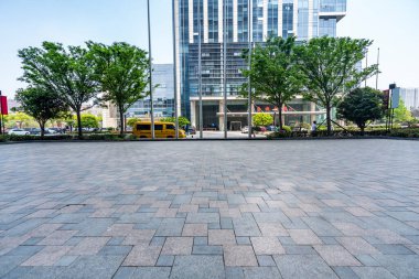 Ağaçları, sarı otobüsü ve binaları olan şehir caddesi. 