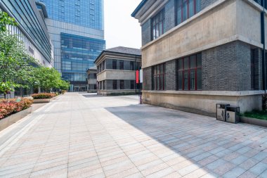 Modern binaları ve ağaçları olan asfalt bir plaza..