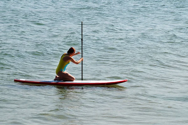 10代の女の子がボード上の海で泳ぐ — ストック写真