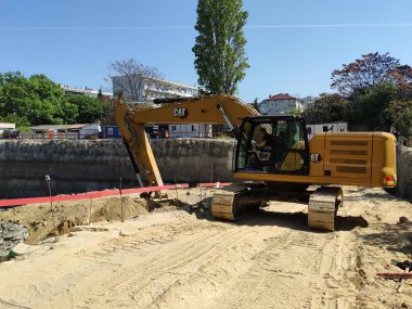 Varna, Bulgaristan - 12 Mayıs 2022: Kazıcı inşaat sahasının altında bir çukur kazıyor