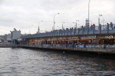 İstanbul, Türkiye - 25 Kasım 2022: Boğazdaki köprünün altındaki kafeler ve dükkanlar