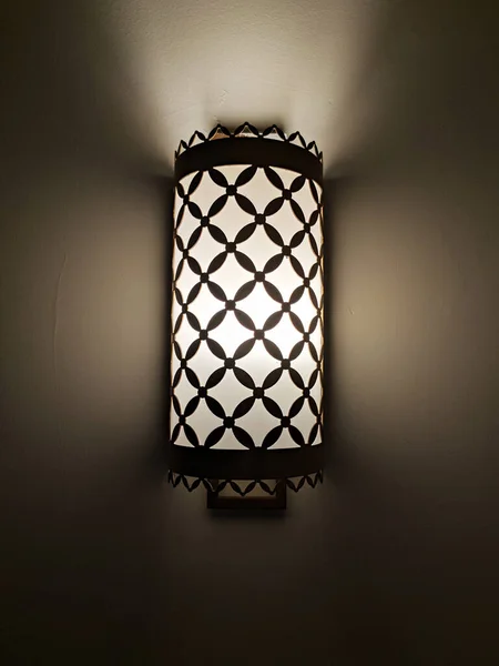 switched on vintage sconce on a dark wall close-up