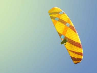 a man flies on a parachute wing in a clear blue sky close-up, copy space, toned photo
