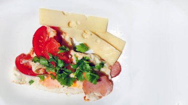 Çırpılmış yumurta, pastırma, domates ve peynirli otlar beyaz arka planda yakın plan, kopyalama alanı.