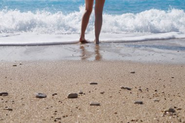 Sahilde çıplak ayaklı kız suyun kenarında, alttaki fotoğrafta..