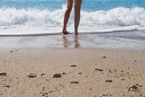 Sahilde çıplak ayaklı kız suyun kenarında, alttaki fotoğrafta..
