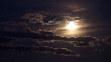 Parlak dolunay gece gökyüzündeki bulutları aydınlatıyor, dramatik gökyüzünü..