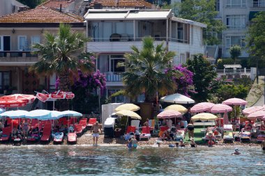 Büyükkada adasında tatil yapan turistlerin olduğu plaj manzarası