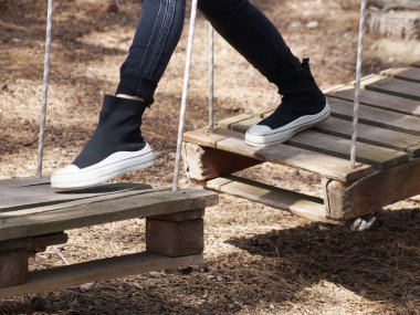 İp eğitimi kursunda, bir kız ahşap paletlerden yapılmış asılmış bir yapıda yürüyor.